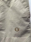 Mens original 1980s Fred Perry Sportswear shorts in tan. Zip fastening and waist button fastening adjustment with classic embroidered Fred Perry logo.